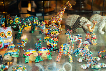 Colorful souvenirs made in Trencadis technique, traditional Catalan mosaic technique, on showcase of Barcelona gift shop ..