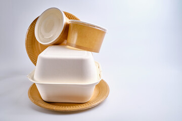 Kraft paper tableware: cups, food boxes, isolated on a light background. A set of various disposable tableware. Recycling and zero waste concept. Mock up
