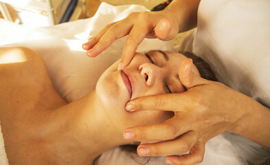 massage therapist doing facial massage, spa procedures, nasolabial folds, aging facial skin,...