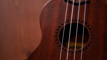 A charming ukulele gracing a wooden table, inviting musical moments with its acoustic allure and...