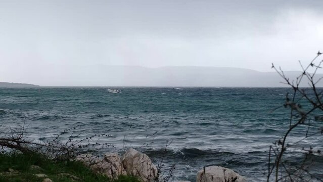 Motorboat moving on the disquiet wavy sea surface near Njivice, Croatia. One day after Storm Ciar&aacute;n - also called Emir - smashed into Krk Island with strong winds and driving rain.
