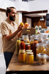 Green living man purchasing locally grown lemons in sustainable zero waste supermarket. Customer happy to find eco friendly chemicals free organic fruits in local neighborhood store