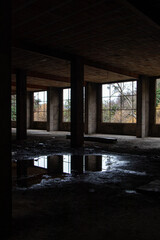 Interior of old abandoned building, large windows, bay windows, puddle, decrepit