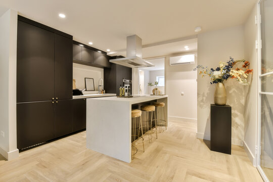 a kitchen with a white island and black cabinets