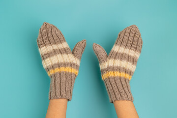 Woolen knitted mittens on hands