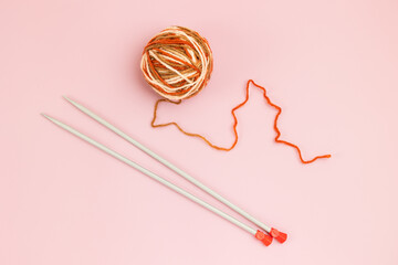 A ball of knitting threads and knitting needles on a light background. Knitting accessories concept.