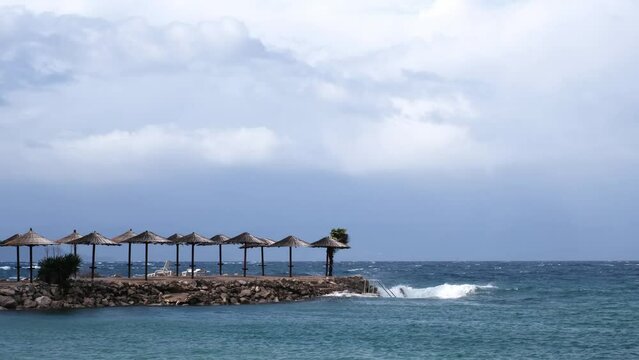 Powerful waves crashing the coast of Njivice, Croatia one day after Storm Ciar&aacute;n smashed into Krk Island. Beautiful disquiet blue sea surface on a rainy day. Cinematic water splashes.