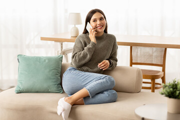 Attractive smiling young brunette woman talking on cell phone