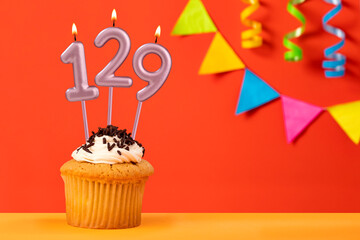 Number 129 Candle - Birthday cupcake on orange background with bunting