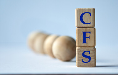 CFS - acronym on a wooden block on a white background with wooden balls