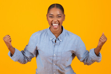 black lady screaming with joy shaking fists over yellow background