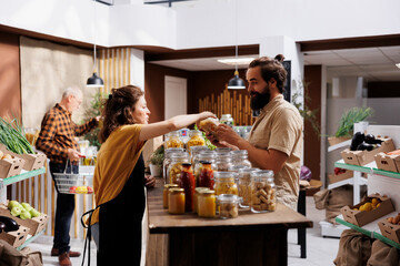 Farmer showcasing her products in zero waste marketplace venue, trading pesticides free food to...