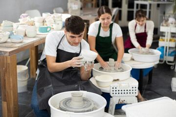 Young man holding finished pottery made on potter's wheel