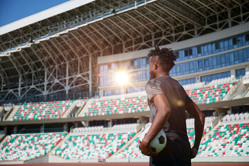 African-American soccer player on training drill. Legs of footballer running on grass practice field