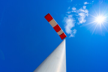 windsock in operation with strong blue sky background with sun
