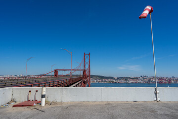 windsock in operation with white background at the entrance of the 25 de Abril suspension bridge in...