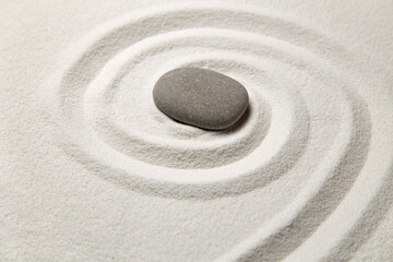 Fototapeta na wymiar Single stone on white sand pattern