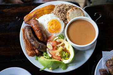 large pandeja paisa in a colombian restaurant with salad beef pork beans and rice