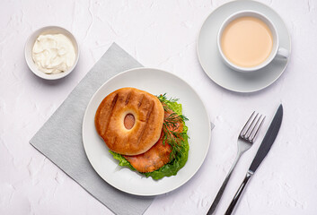 Food photography of bagel with  smoked salmon, cream, dill, romaine lettuce, tea with milk, sandwich, morning, slice, breakfast, brunch