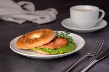 Food photography of bagel with  smoked salmon, cream, dill, romaine lettuce, tea with milk, sandwich, morning, slice, breakfast, brunch
