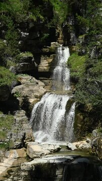 The upper part of a threefold waterfall with a pond, vertical shot