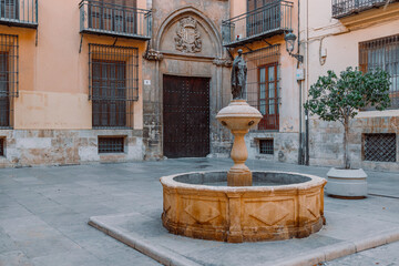 Fototapeta na wymiar Ancient fountain on a narrow street on a sunny day. Valencia,SpainHigh quality photo