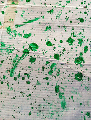 Abstract green paint grunge background. Dirty white cardboard with green paint stains and drops. Hand painted illustration.