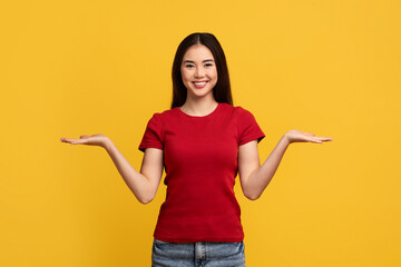 Cheerful young korean woman holding something invisible on both hands