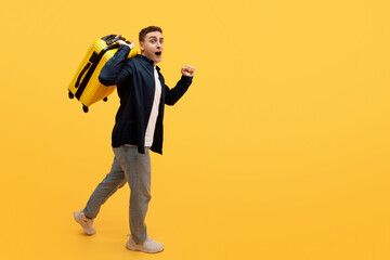 Young caucasian guy tourist with suitcase on his shoulder