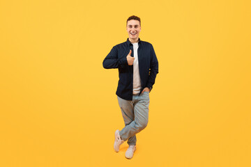 Positive stylish young guy showing thumb up and smiling