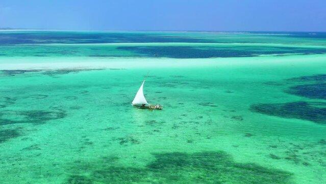 Stunning view of Tanzanian sailors and their dhow by the beach.