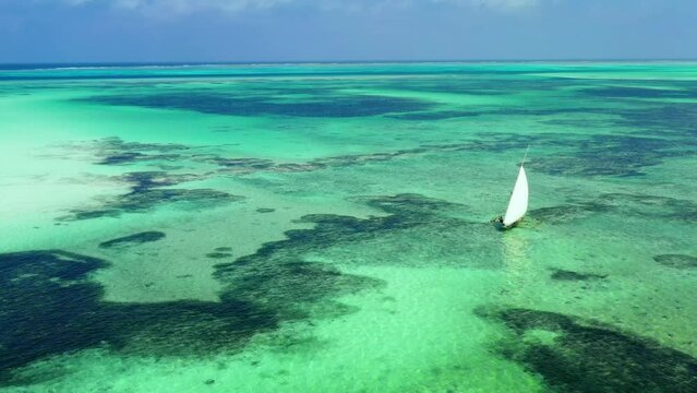 Aerial shot of small boat floating alone on the shallow water.