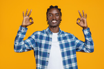 Happy young black man making the OK sign with both hands