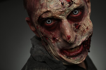 Scary zombie on dark background, closeup. Halloween monster