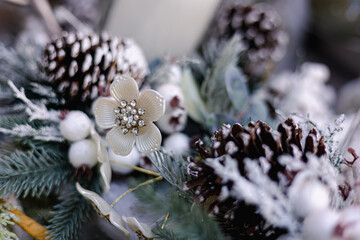 christmas decoration branches with flower, cones and snow, winter outdoor environment, seasonal decoration