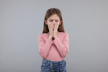 Sick girl coughing on gray background. Cold symptoms