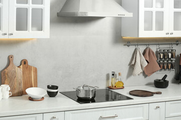 Wooden cutting boards and other cooking utensils on white countertop in kitchen