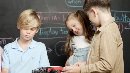 Group of caucasian student checks robotic model while taking a note.at blackboard with engineering...