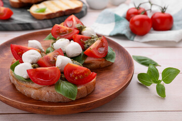 Delicious Caprese sandwiches with mozzarella, tomatoes, basil and pesto sauce on white wooden table, closeup
