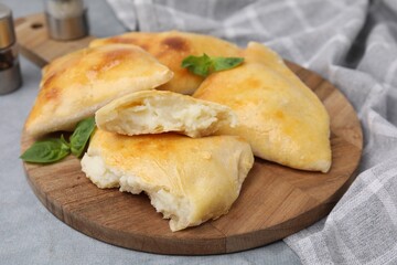 Delicious samosas and basil on grey table