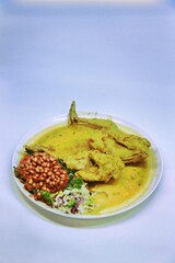 Balinese Indonesian food, Ayam Betutu. Whole chicken filled with Balinese seasoning cassava leaves, wrapped in banana leaves and steamed. Served with Sambal Matah and Roasted Peanuts.