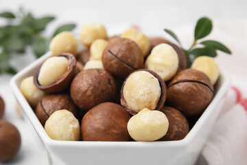 Tasty Macadamia nuts in bowl, closeup view