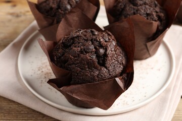 Tasty chocolate muffins on wooden table, closeup
