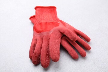 Pair of red gardening gloves on light grey table