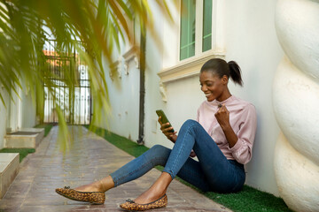 Woman Sitting on Ground Holding Cell Phone