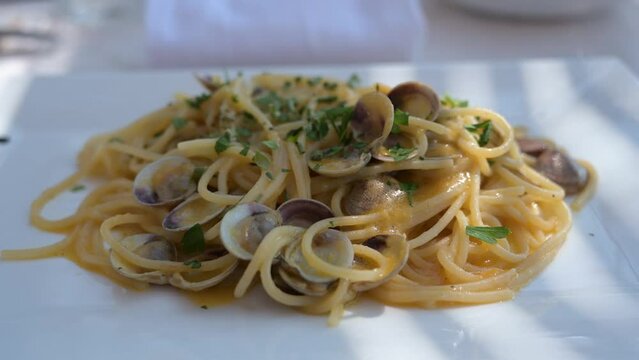 spaghetti con le vongole servito su di un piatto bianco al ristorante