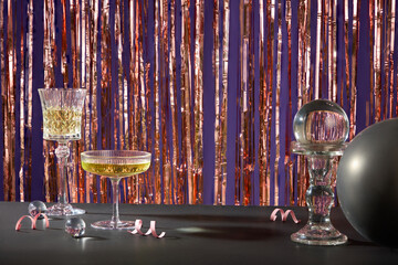Black table featured some glasses of wine and a black balloon. Silver foil tinsel strips decorated...