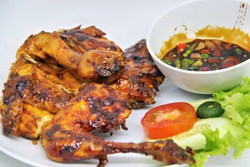 Bakakak Hayam or Ayam Bekakak or Grilled Whole Chicken with seasonings plus soy sauce, a dish from West Java and Jakarta, Indonesia. Usually served to brides at weddings.