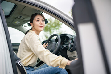 自動車のドアを開けるドライバーの女性