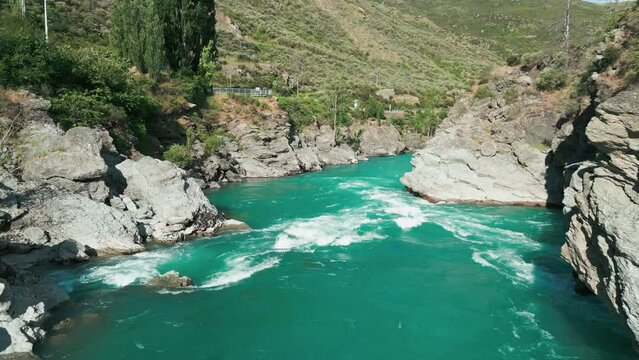 Drone between two mountains low pass over raging river
